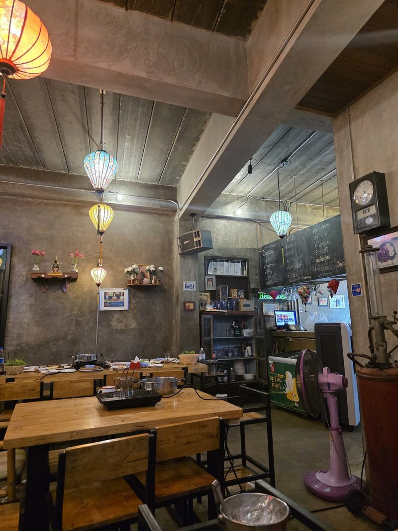 มุมหนึ่งของร้าน มีโคมผ้า นาฬิกาแขวน และกระดานเมนู